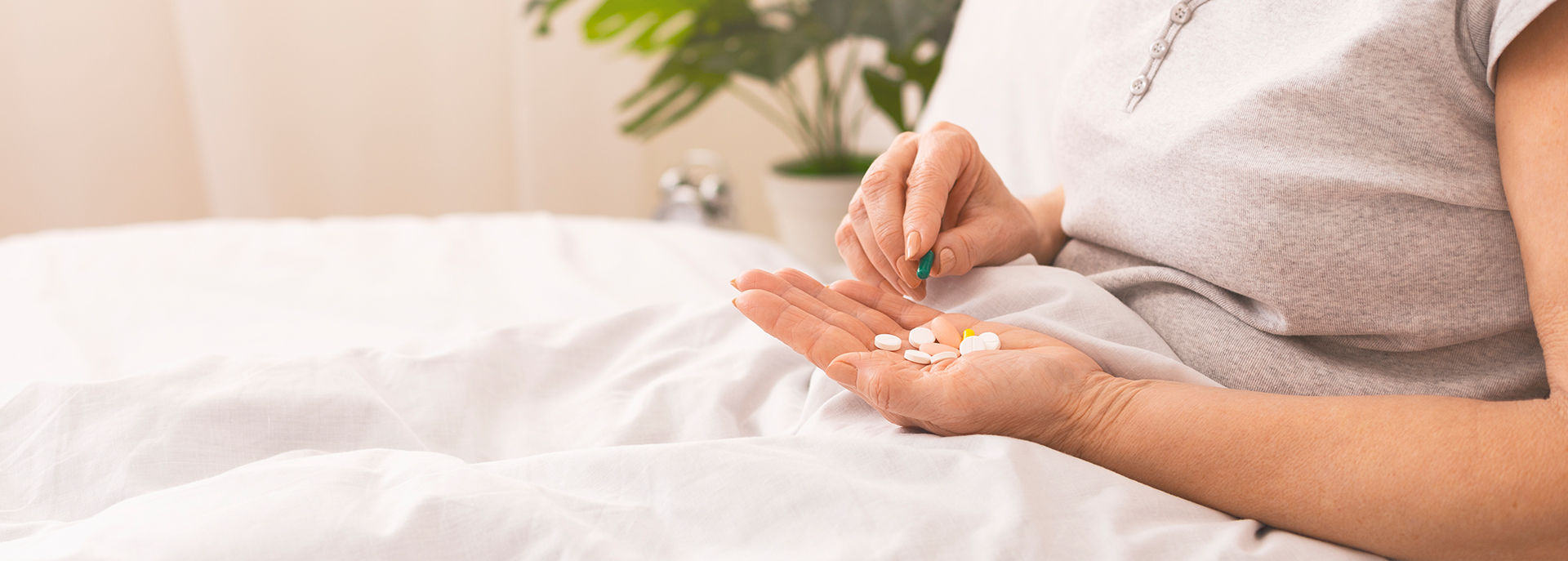 En dame som holder tabletter reseptfrie legemidler i hendene