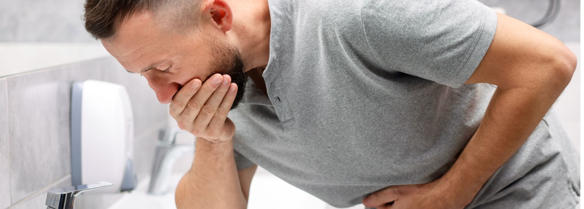 En kvinne som holder seg for magen på grunn av omgangssyke